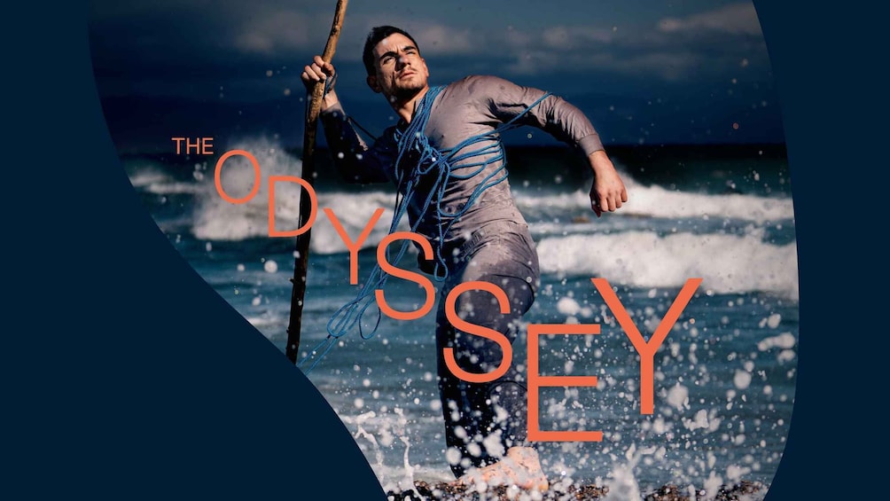 A person in a wetsuit holding a rope, standing in the ocean with waves. 1