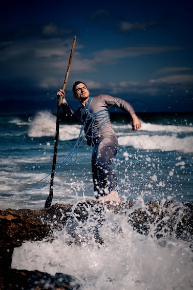 A person surfing with a stick in the ocean. 4