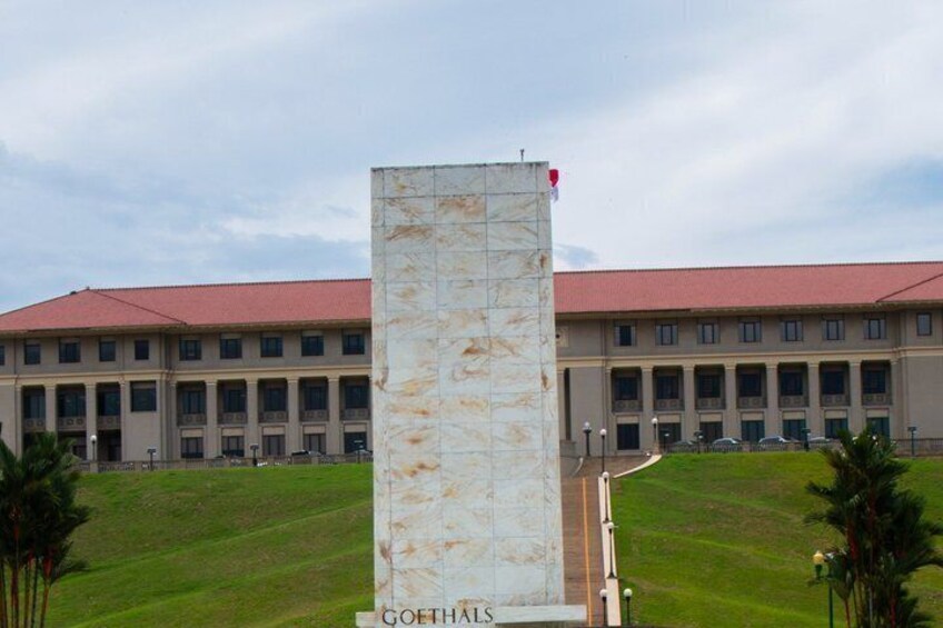 A building with a red roof and a tall white column with 'GOETHALS' inscribed on it. 1