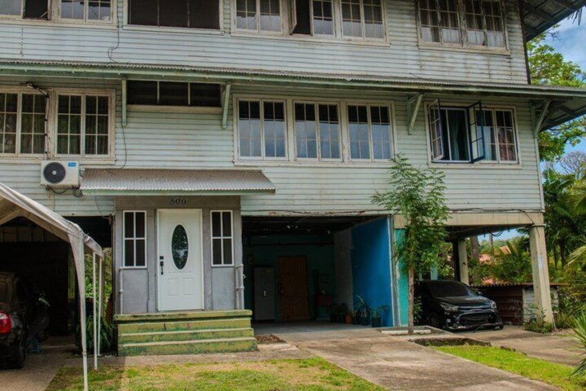 A two-story house with a garage, a car parked outside, and a small tree in the front yard. 4