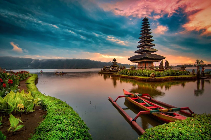 A serene lake with a pagoda, lotus flowers, and a rowboat. 5