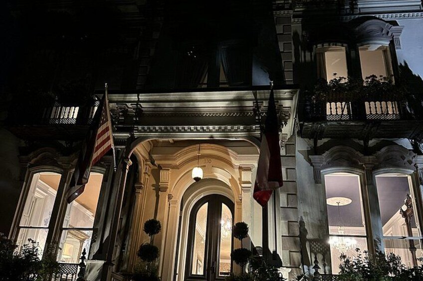 A grand building with an arched entrance, flags, and ornate balconies. 2