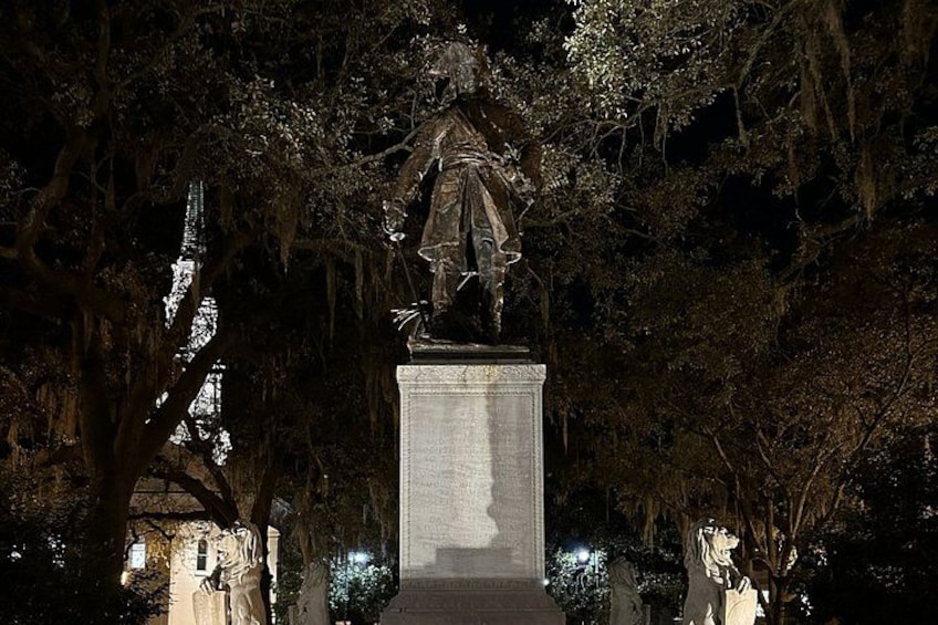 A statue in a park at night. 4