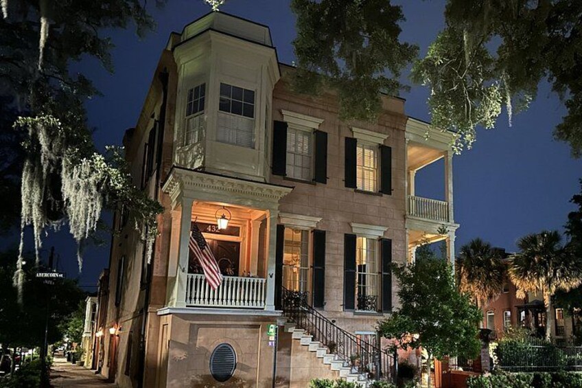 A historic building with a balcony, stairs, and a porch. 5