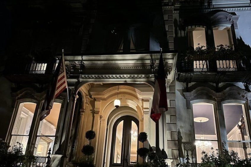 A historic building with an ornate entrance, American flags, and a well-lit facade. 2