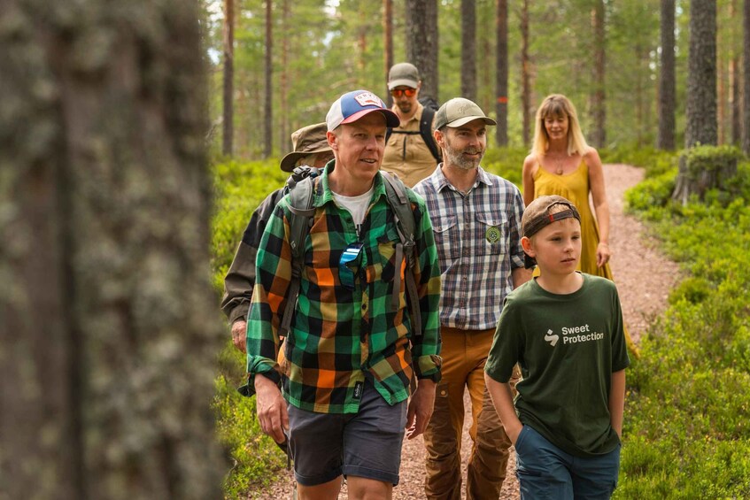 A group of people walking on a forest trail. 1