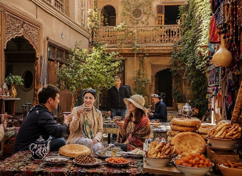 A courtyard with people dining, ornate architecture, and a variety of food items. 5