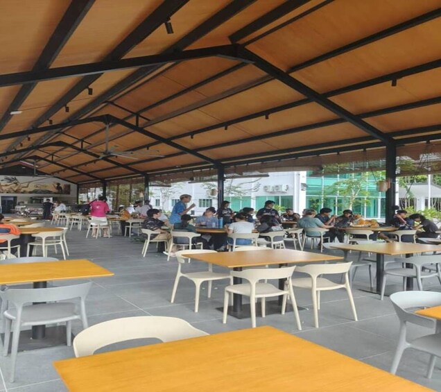 An outdoor café with tables and chairs under a wooden roof. 3