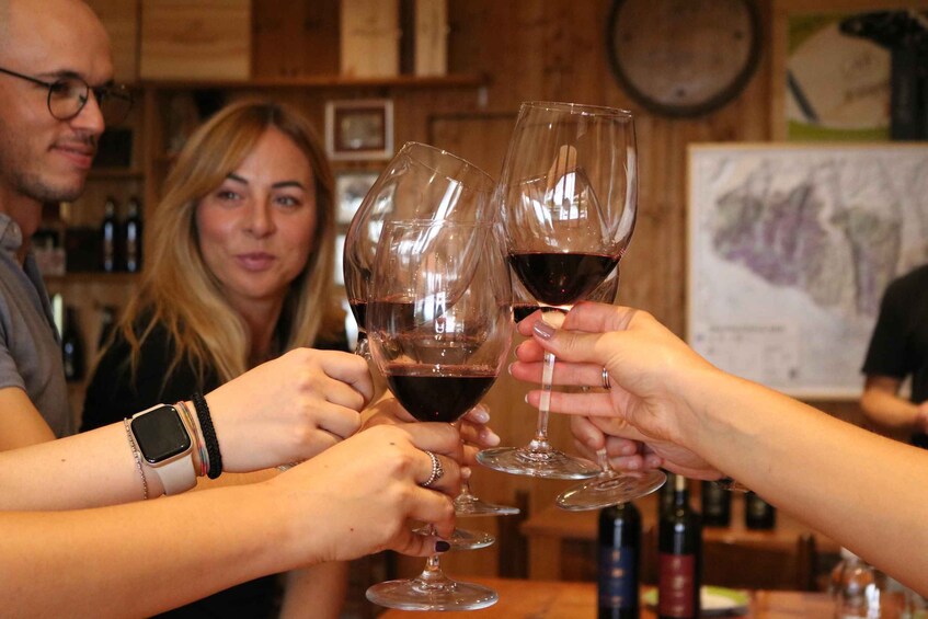 A group of people toasting with wine glasses in a bar setting. 4
