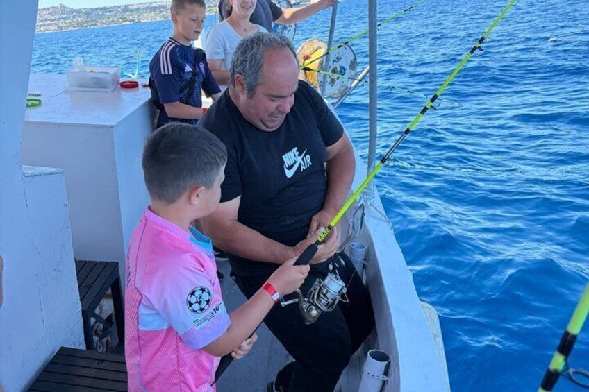 A man and a child on a boat, fishing. 4