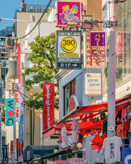 A busy urban street with various signs, including a 'THANK YOU MERT' shop, a 'NEW YORK' hotel sign, and a 'First Kitchen' banner. 3