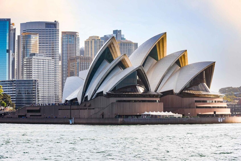 Sydneyoperahuset, med sin karakteristiska design som påminner om segel, omgivet av stadens silhuett. 1
