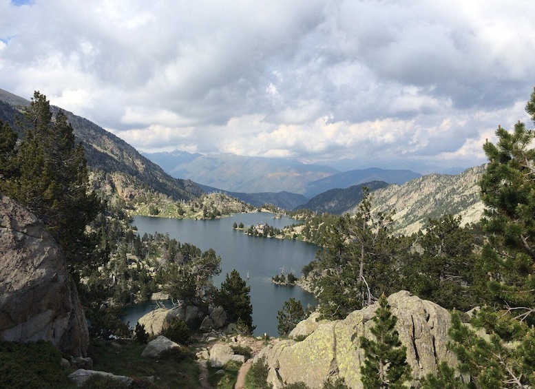 A mountainous landscape with a lake surrounded by trees and rocky terrain. 5