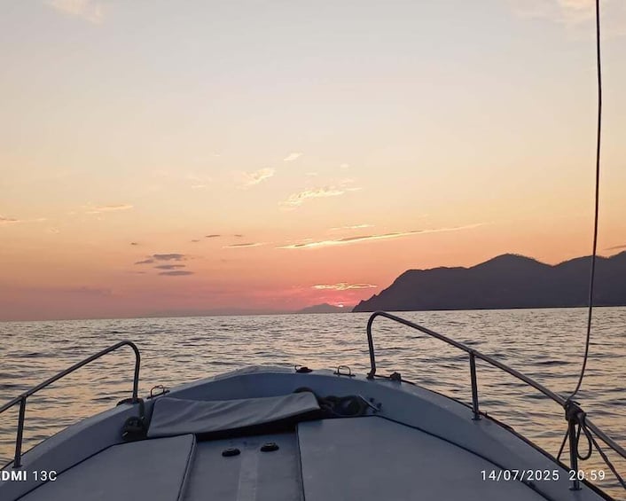 A boat at sunset with mountains in the background. 4