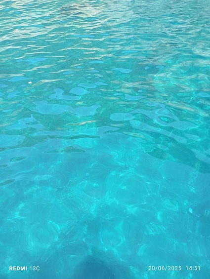 Clear turquoise water with visible ripples and reflections. 2