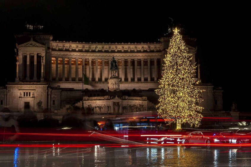 A grand building with classical architecture, a large illuminated Christmas tree, and light trails from vehicles. 5