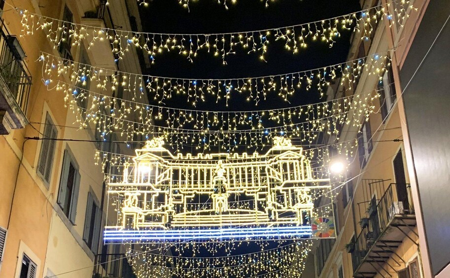 A street at night with string lights and illuminated architectural structures. 4