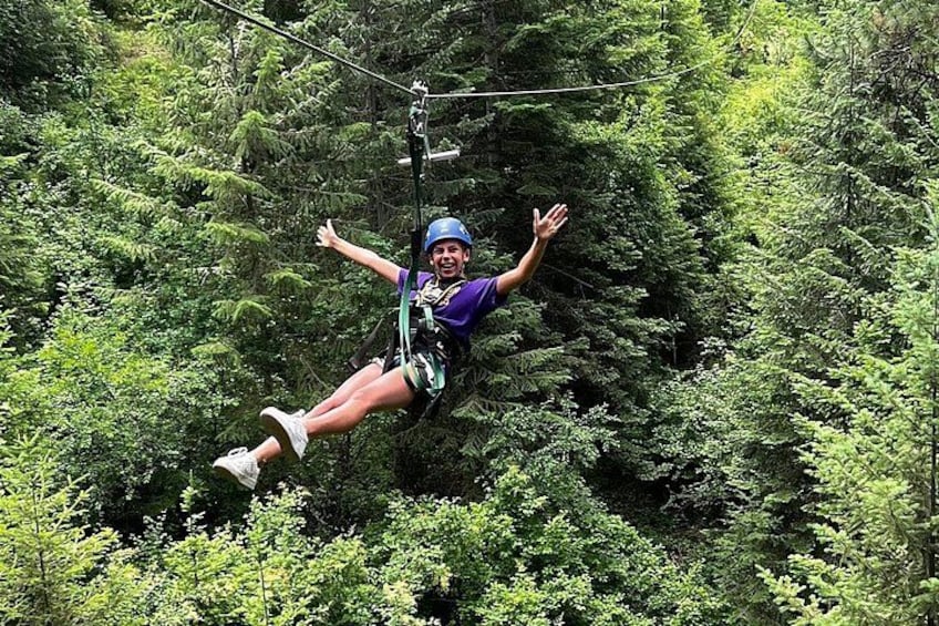 A person zip-lining through a dense forest. 2