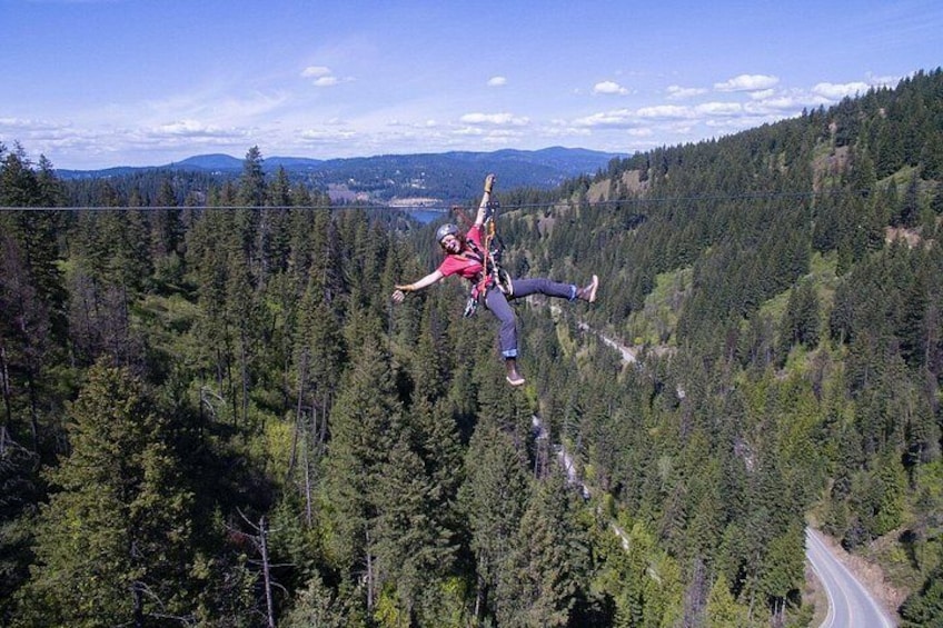 A person bungee jumping from a bridge over a forested valley. 1