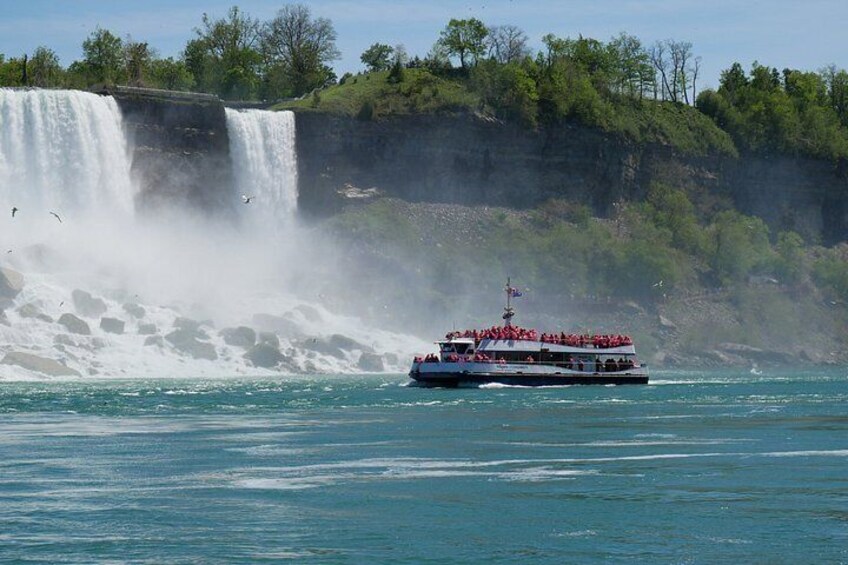 A boat with red seats near a waterfall. 2