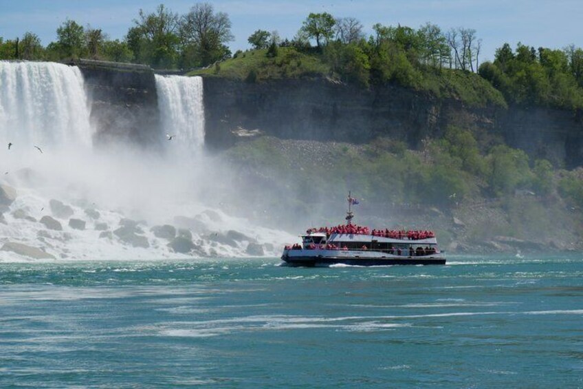 A boat with passengers near a waterfall. 3