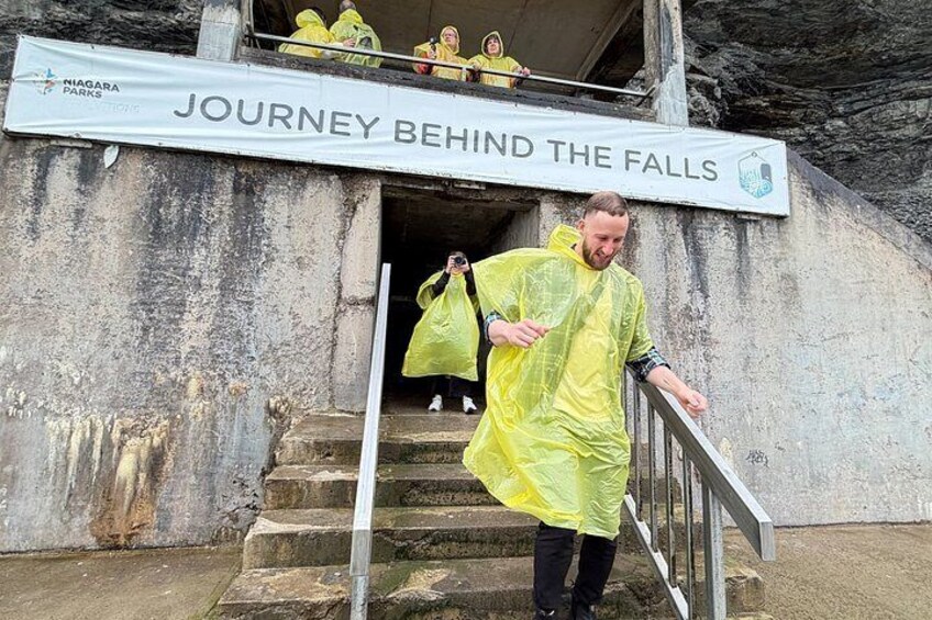 A person descending a set of stairs with a sign reading 'JOURNEY BEHIND THE FALLS' above. 3