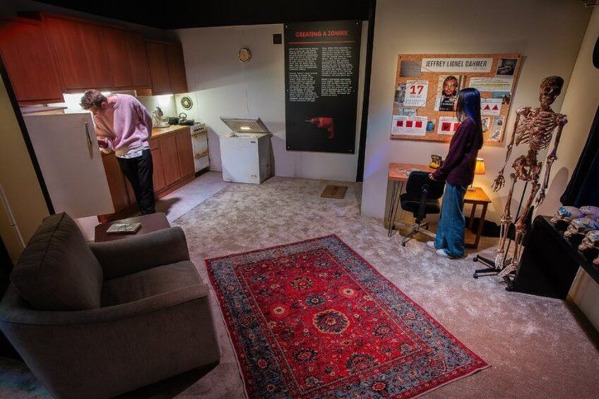 A room with a red patterned rug, a skeleton display, and a poster with a person's name and age. 2