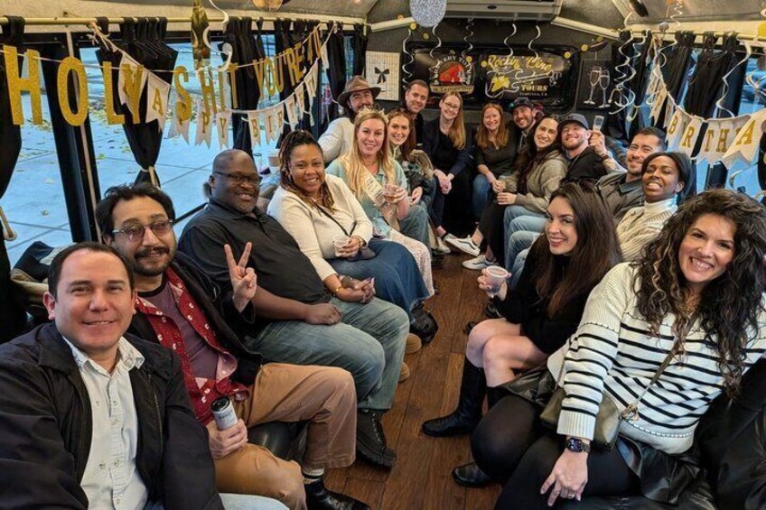 A group of people seated inside a boat, with a banner reading 'HOLY SHIT YOU'RE BIRTHDAY' visible. 5