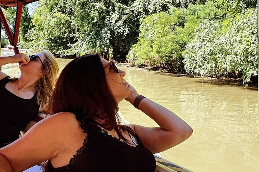 Two women on a boat near a river with dense greenery on the banks. 5