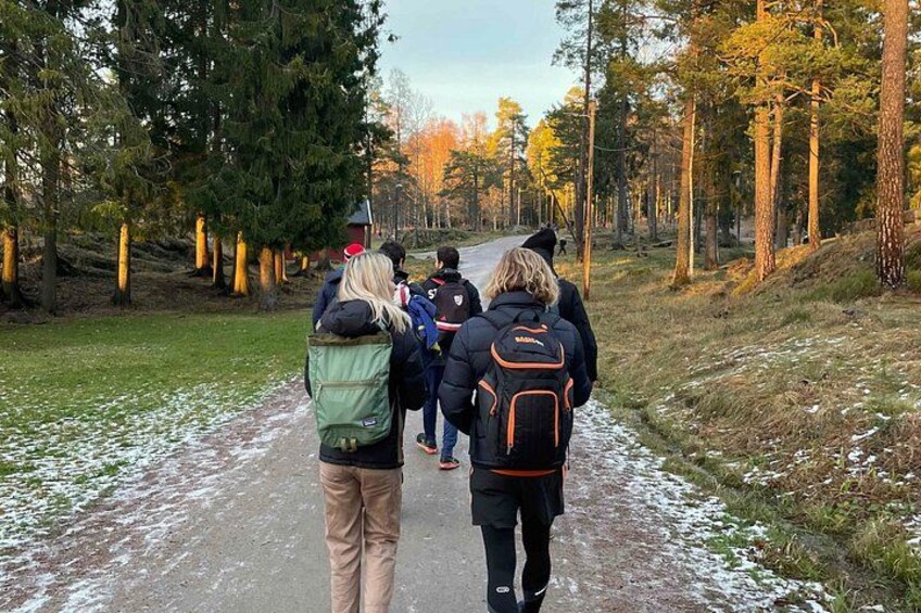 A group of people walking on a snow-covered path in a forest. 1