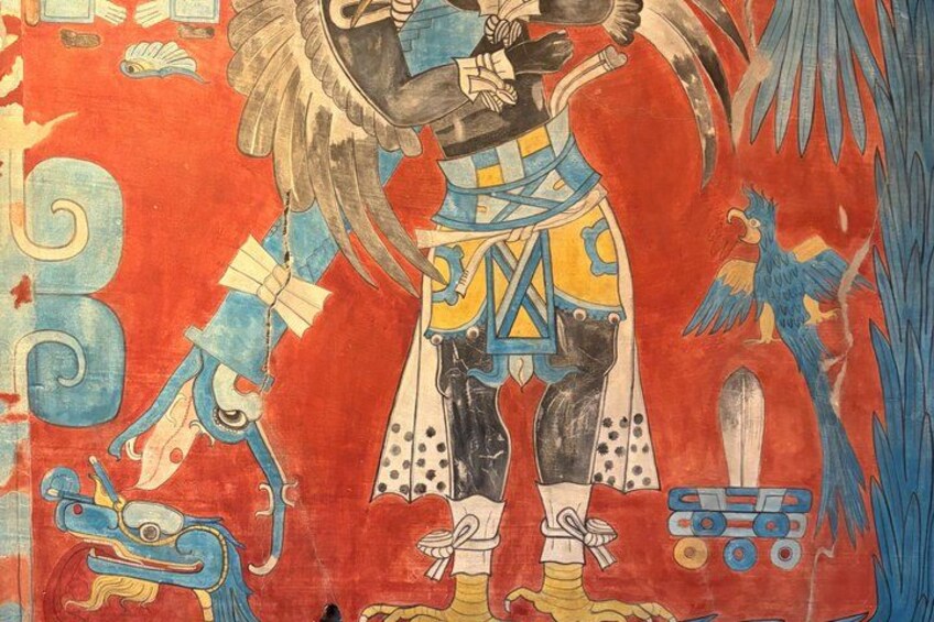 A mural with a figure in traditional attire, geometric patterns, and stylized birds. 5