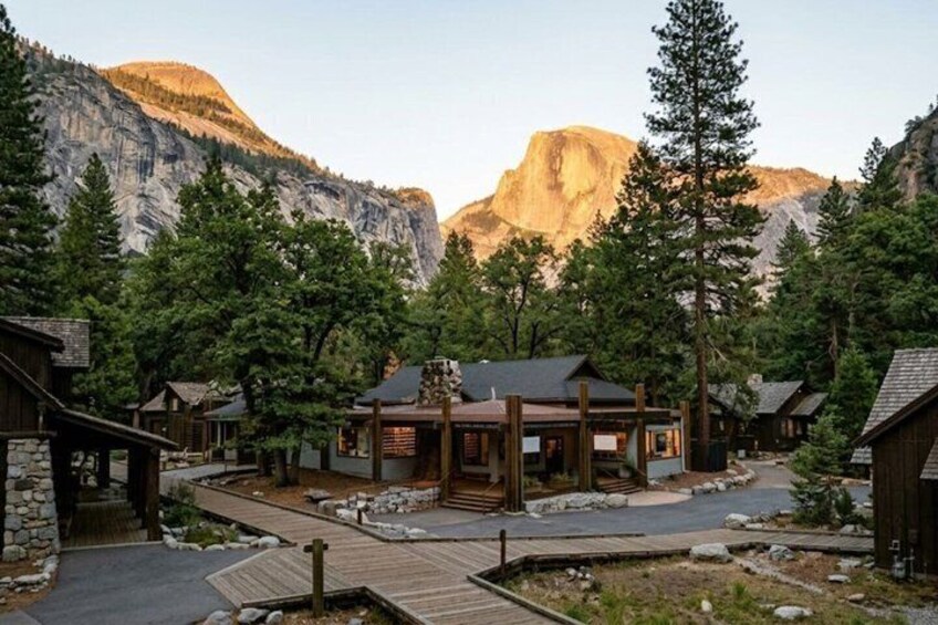 A lodge with a wooden deck, surrounded by trees and mountains. 4