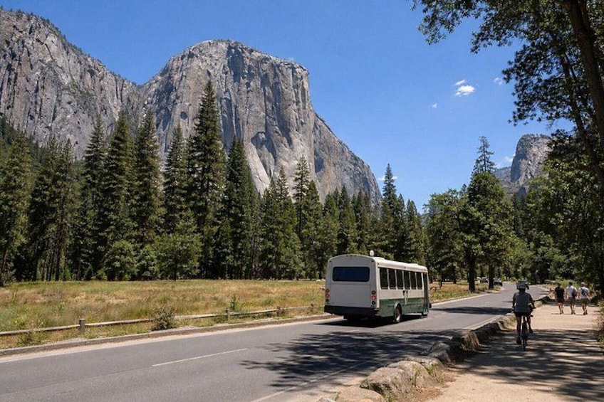 A bus on a road with mountains in the background. 4