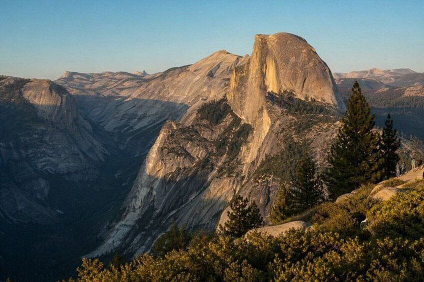 A mountain landscape with a prominent rock formation, dense forest, and a valley. 2