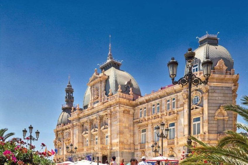 A historic building with ornate architecture, domes, and a clear blue sky. 4