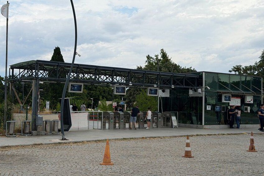 A toll booth with multiple lanes, traffic cones, and a pedestrian walkway. 5