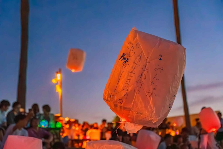 A crowd at dusk with paper lanterns. 4