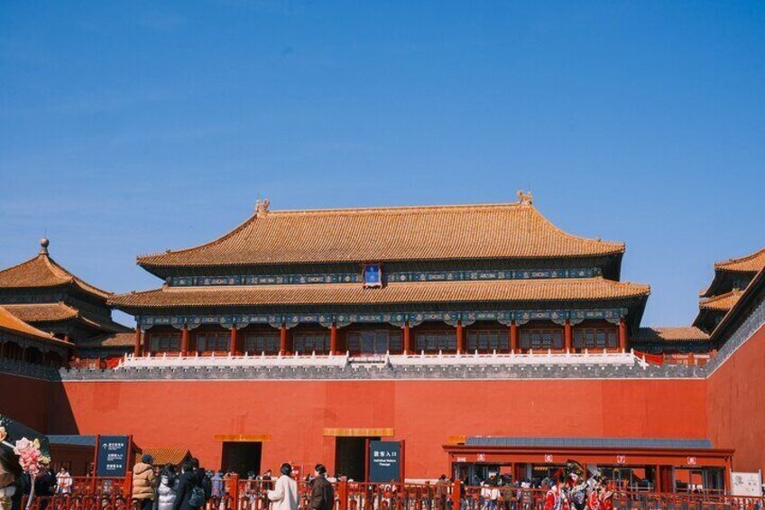 A traditional Chinese building with a tiled roof and red walls, surrounded by a courtyard with visitors. 3