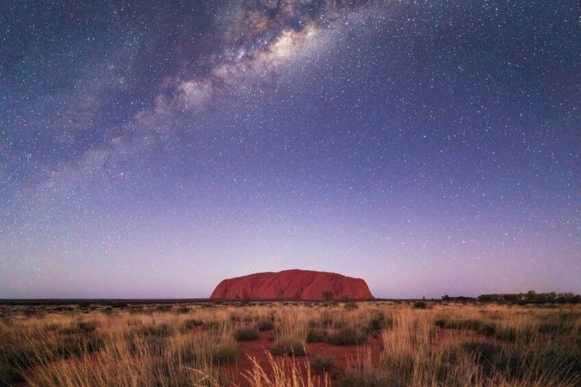 A starry night sky with the Milky Way over a red rock formation. 1