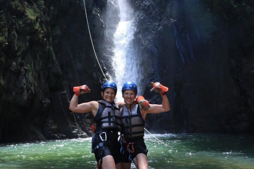 Two people in a cave with a waterfall. 3