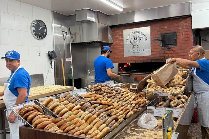 A bakery with a sign reading 'ST-VITAEUR BAGEL MONTREAL' and a clock on the wall. 3