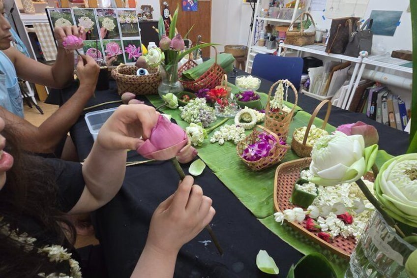 A table with various flowers and baskets. 5