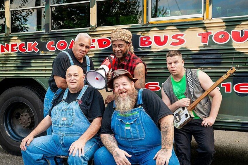 A group of people sitting on a bus with 'NECK COATED BUS TOUR' written on it. 1