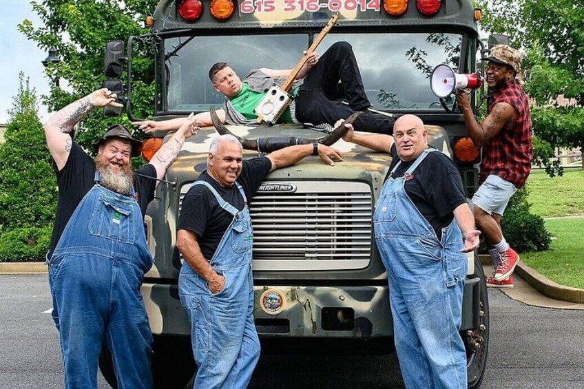 A group of men posing in front of a military-style vehicle with a phone number on the side. 5