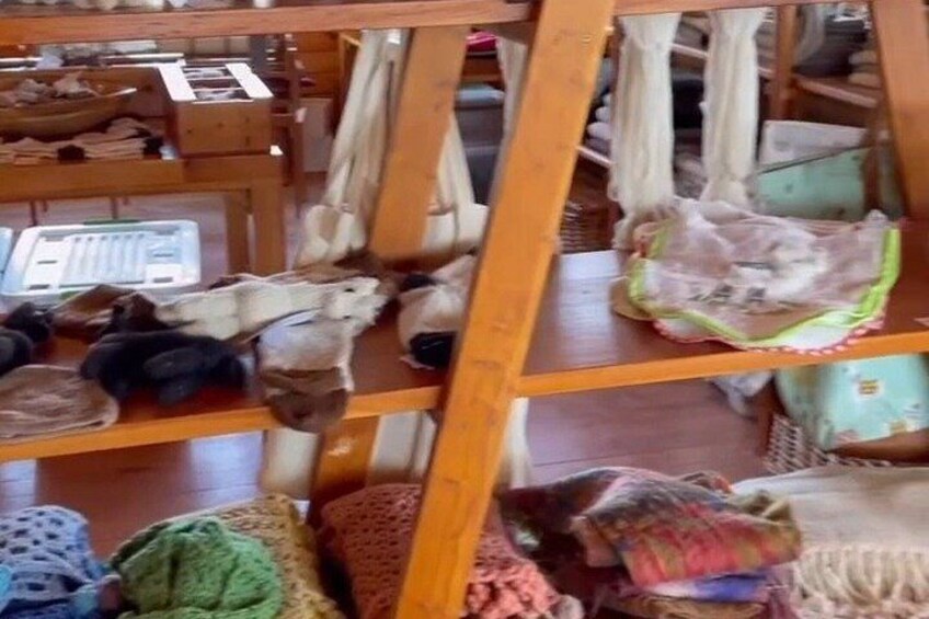 A wooden ladder with various items on shelves, including bags and a basket. 4