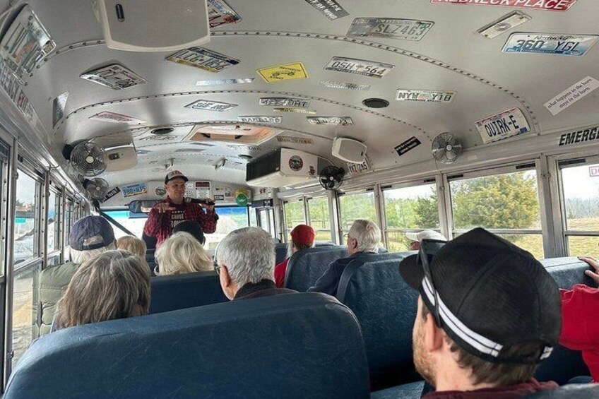 The interior of a bus with passengers seated and a driver at the front. 4