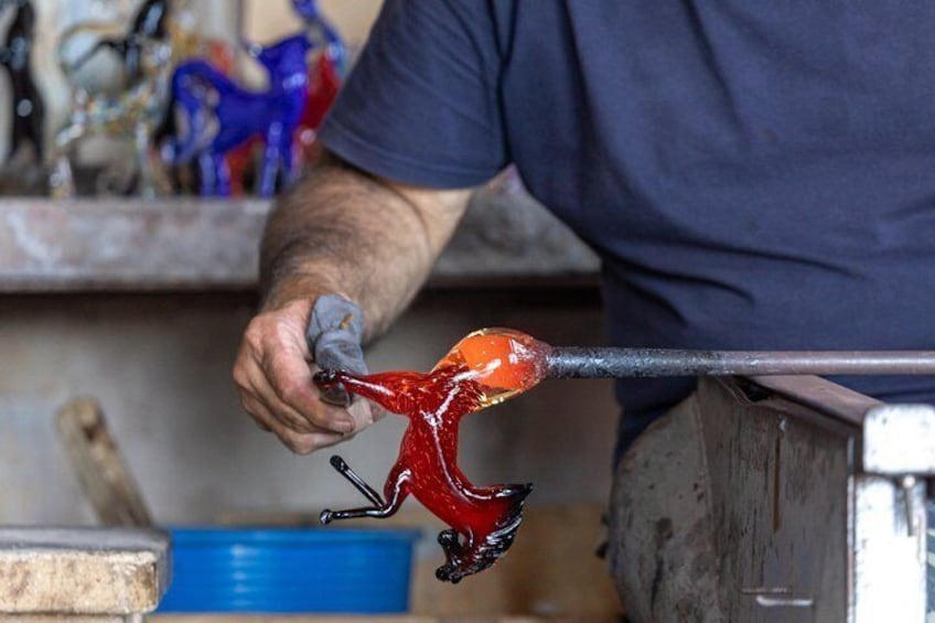 A person working with a glass object on a furnace. 3
