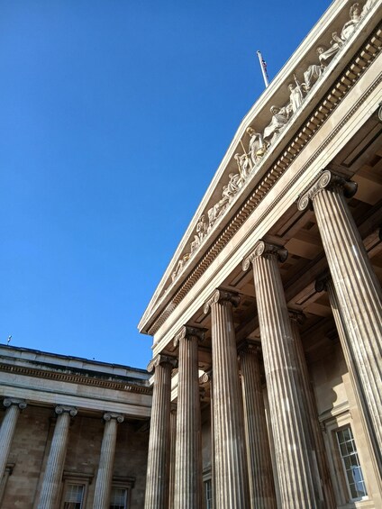 A neoclassical building with Corinthian columns and a frieze depicting figures. 1