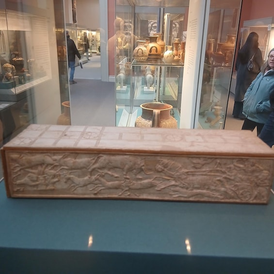 A museum display with ancient pottery and a large carved stone slab. 2