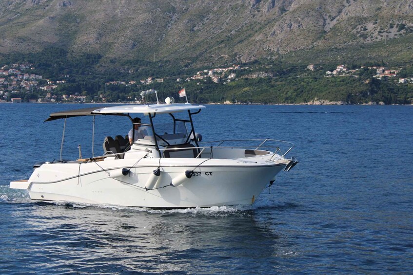 A white motorboat with the registration number 537 CT on a calm body of water. 2